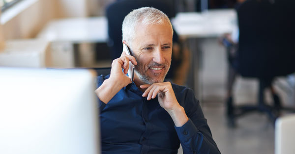Un individu se prépare à contacter quelqu'un, concentré et tenant un appareil.