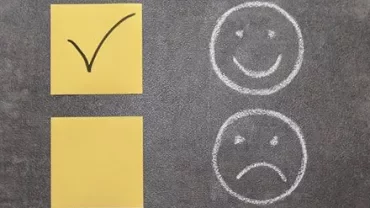 Yellow sticky notes with a checkmark, next to chalk-drawn happy and sad faces.